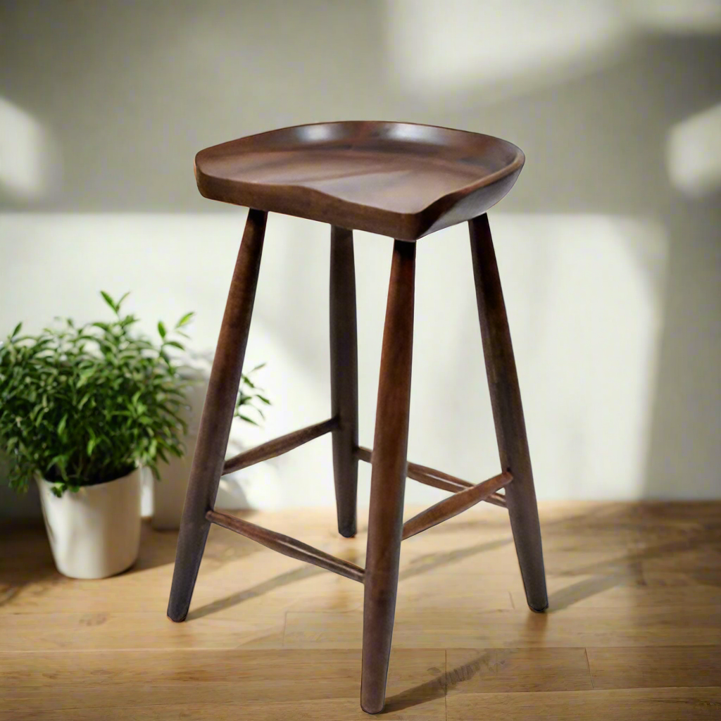 A brown solid wood bar stool with a smooth seat and tapered legs.
