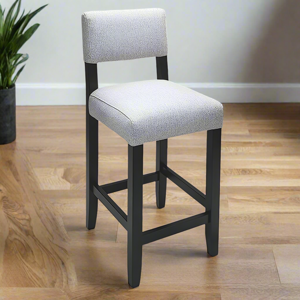 Gray cushioned bar stool with black legs on a white background