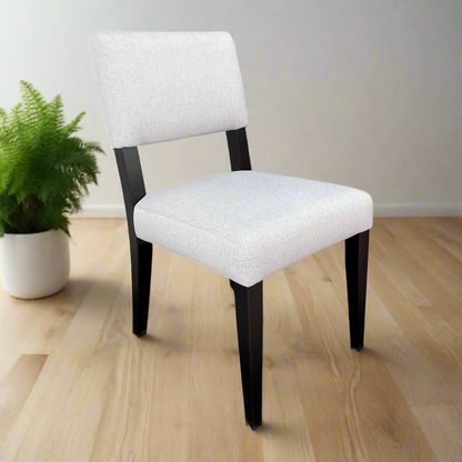 White upholstered chair with black legs on a white background