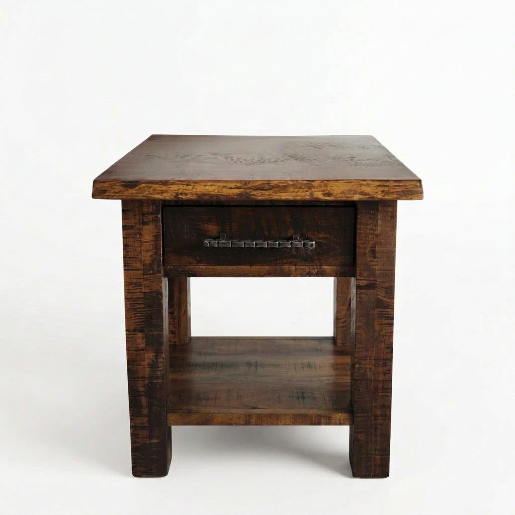 A rustic dark brown wooden end table with a single drawer, featuring a carved top surface and an open lower shelf, set against a plain white background.