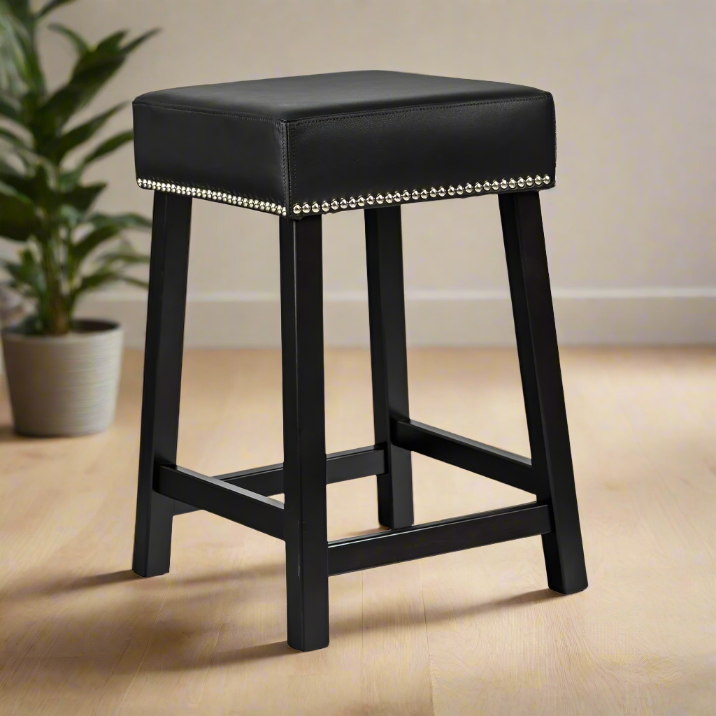 Black bar stool with leather seat and nailhead trim on a white background