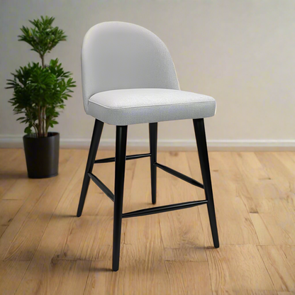 Gray cushioned bar stool with black legs on a white background