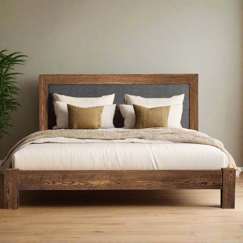 Wooden bed with white bedding and decorative pillows on a white background