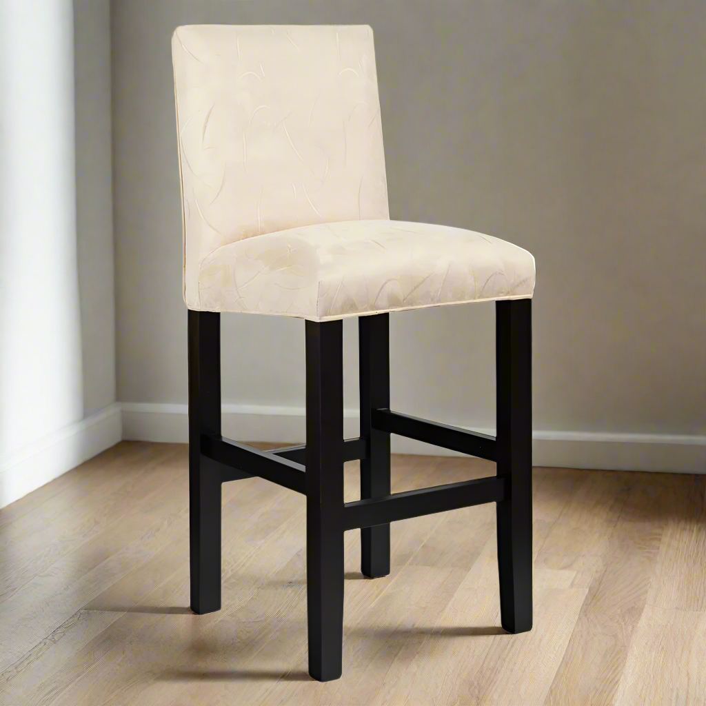 Bar stool with beige cushioned seat and black legs on a white background